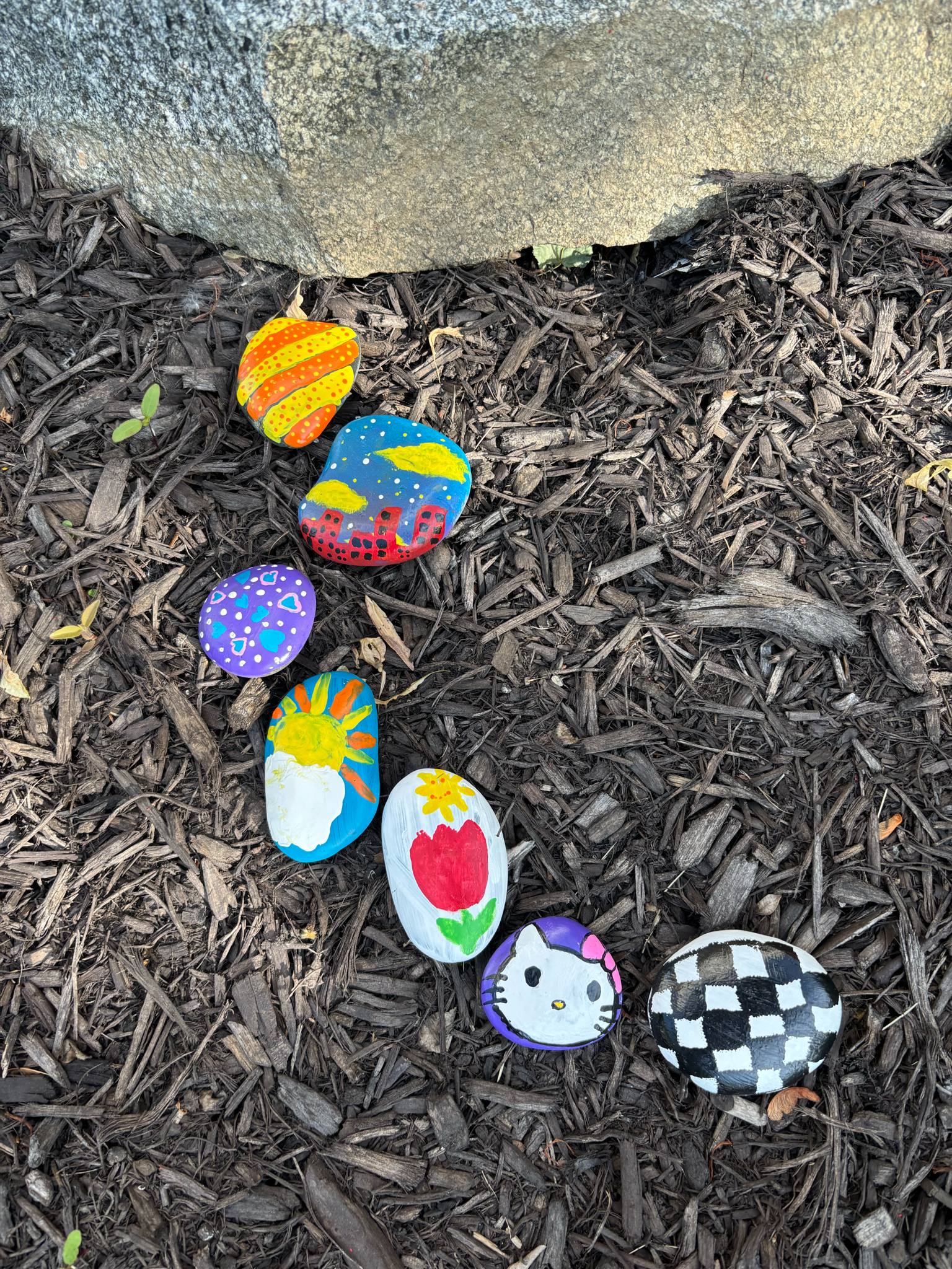 Painted rocks outside of the library forming the start of a road